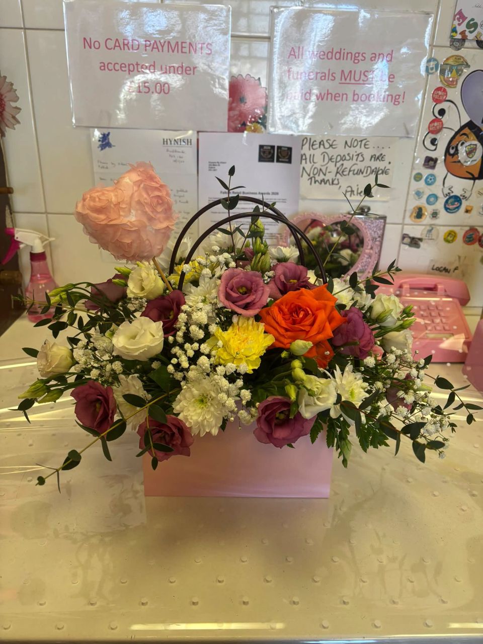 Flower arrangement in a pink box with a handle