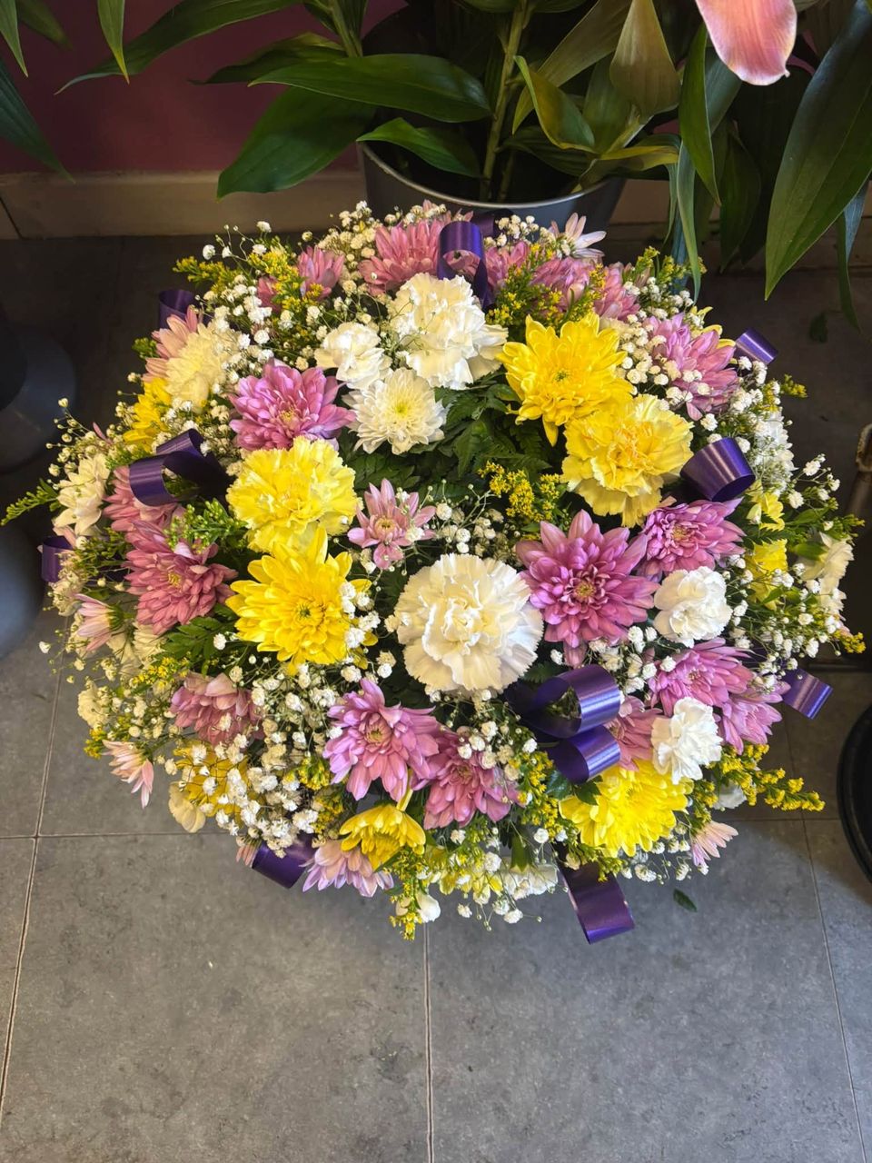 Round posy of yellow, lilac and cream flowers