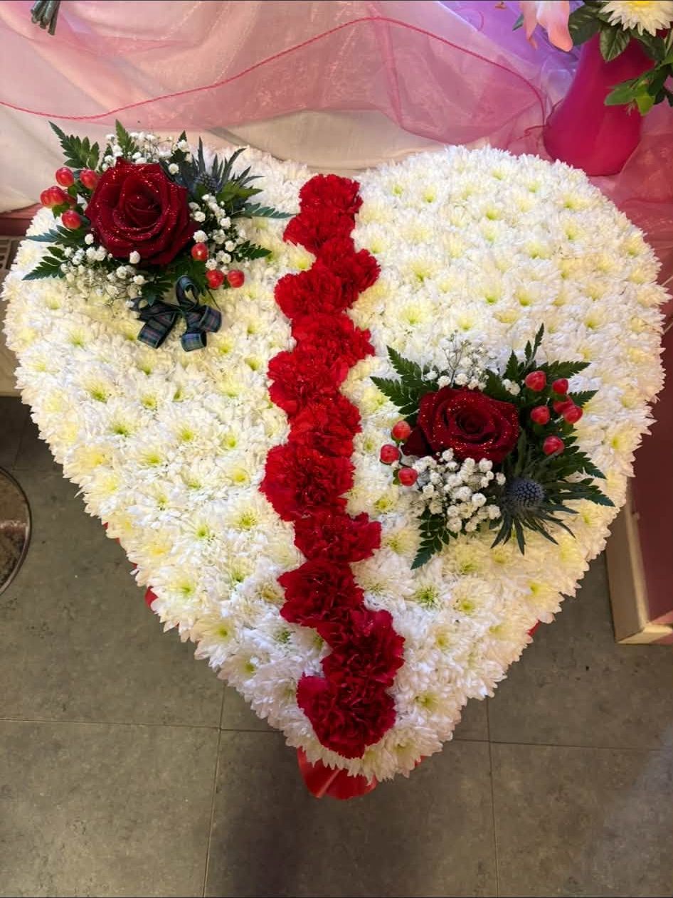 Heart tribute in white with a line of red roses